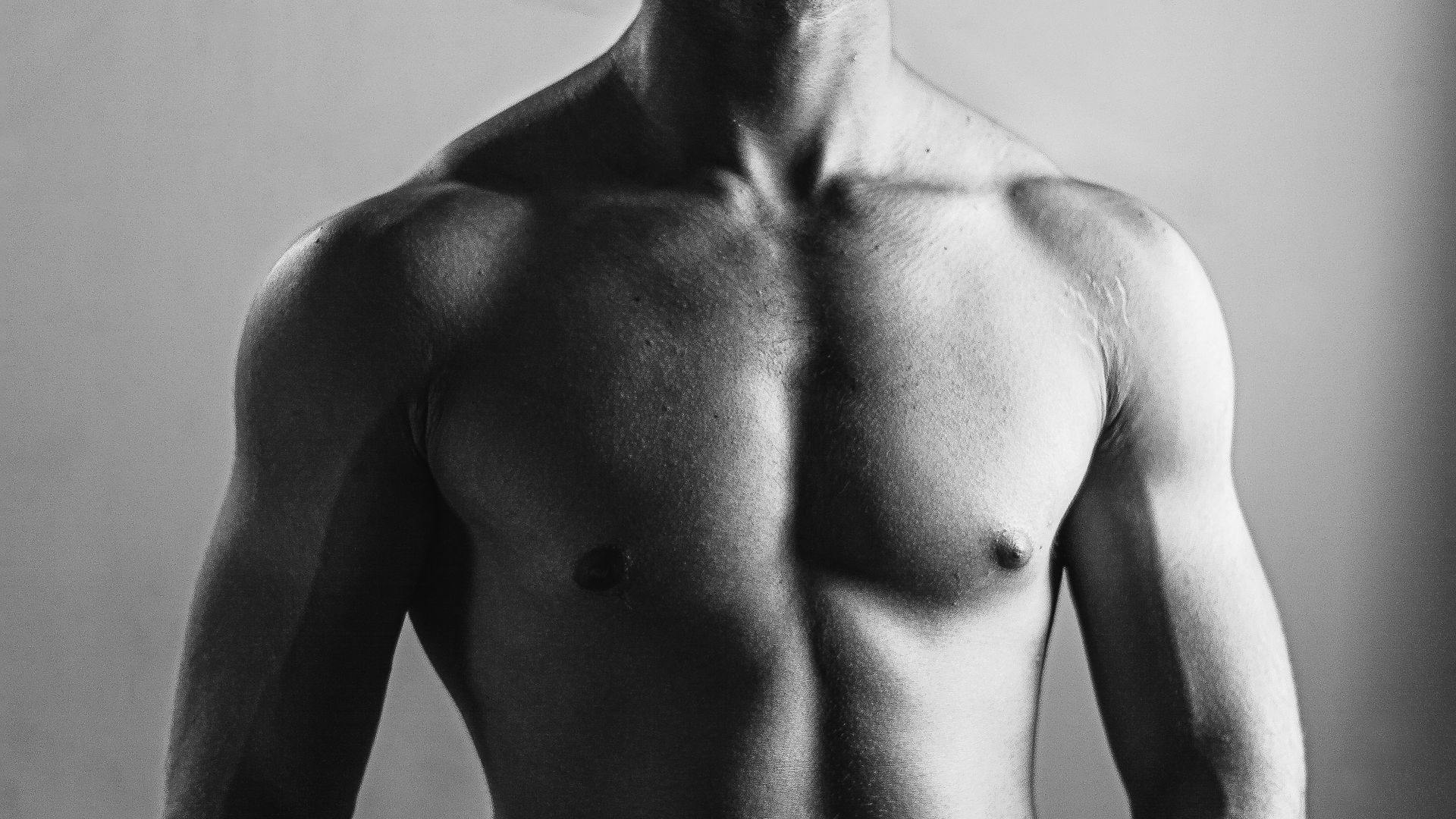 Torso masculino en blanco y negro con pectorales y hombros definidos, imagen de referencia sobre Lipo Vaser HD en hombres